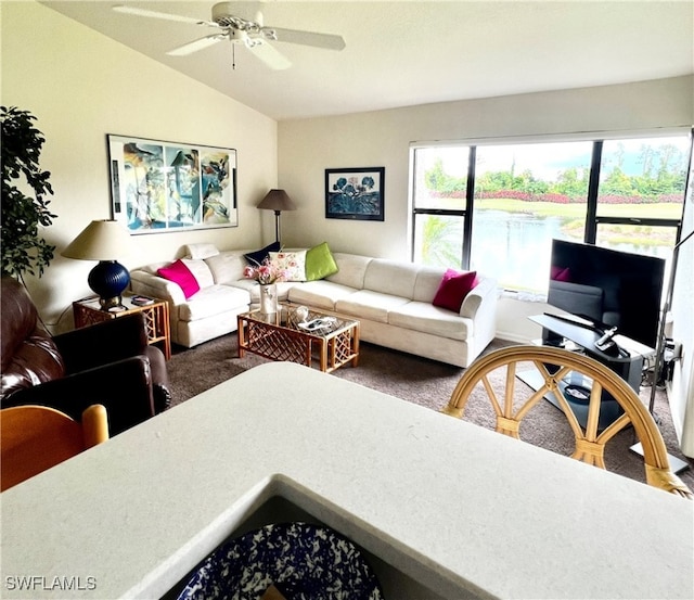 living room featuring ceiling fan, carpet flooring, and vaulted ceiling