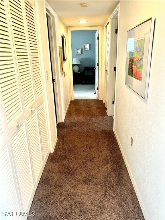 hallway with dark colored carpet