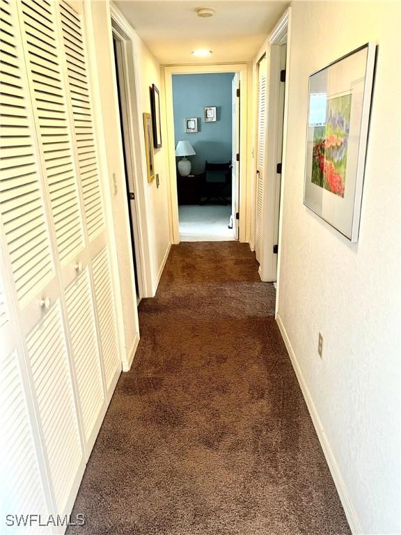 5925 Trailwinds Dr Unit 926, Fort Myers, FL 33907 - hall featuring dark colored carpet and baseboards