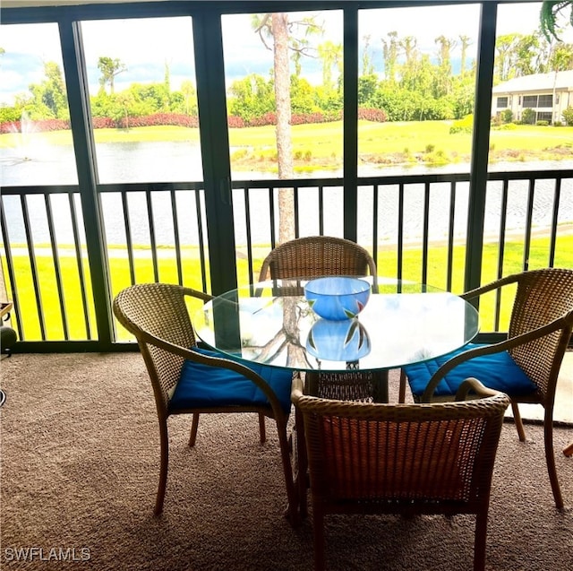 sunroom featuring a water view