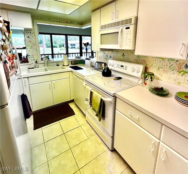 kitchen featuring white appliances, sink, and light tile patterned floors