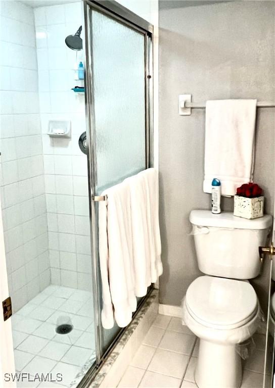 5925 Trailwinds Dr Unit 926, Fort Myers, FL 33907 - full bathroom with tile patterned floors, toilet, a stall shower, and baseboards