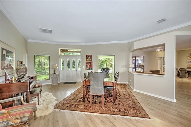 dining area featuring light hardwood / wood-style flooring and crown molding