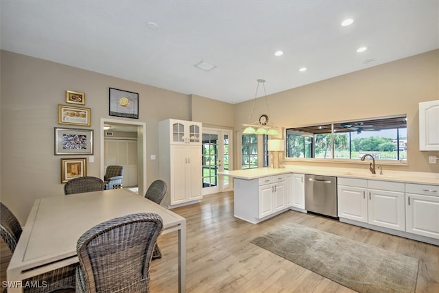 kitchen with light wood-type flooring, white cabinets, kitchen peninsula, decorative light fixtures, and stainless steel dishwasher