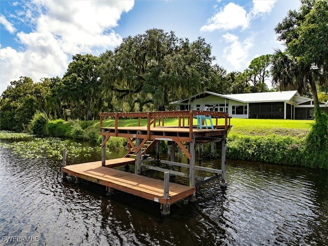 dock area with a lawn and a water view