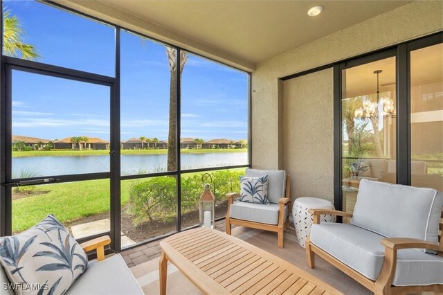 sunroom with a water view, an inviting chandelier, and plenty of natural light