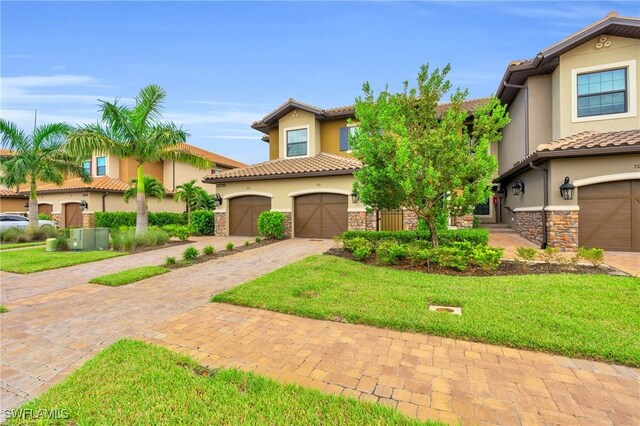 mediterranean / spanish-style home featuring a garage and a front lawn