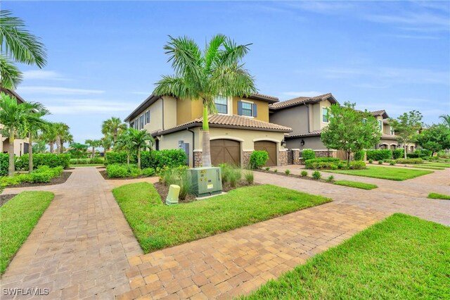 mediterranean / spanish-style house with cooling unit, a garage, and a front yard