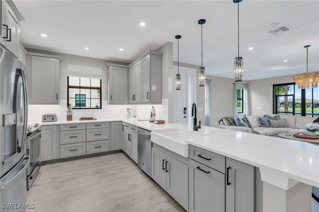 kitchen featuring pendant lighting, gray cabinets, and sink