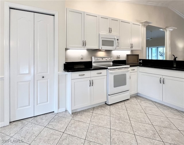 kitchen featuring white appliances, vaulted ceiling, white cabinetry, and ornate columns