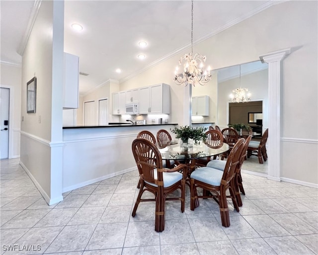 dining space with light tile patterned flooring, lofted ceiling, ornamental molding, a chandelier, and decorative columns