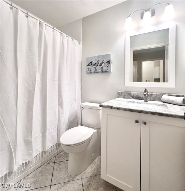 bathroom featuring walk in shower, vanity, toilet, and tile patterned floors