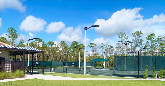 view of tennis court featuring a yard