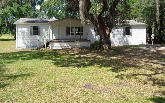 single story home featuring a front lawn and an outbuilding