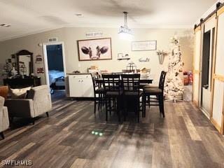 dining space featuring a barn door, dark hardwood / wood-style floors, and lofted ceiling