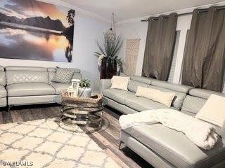 living room featuring crown molding and wood-type flooring