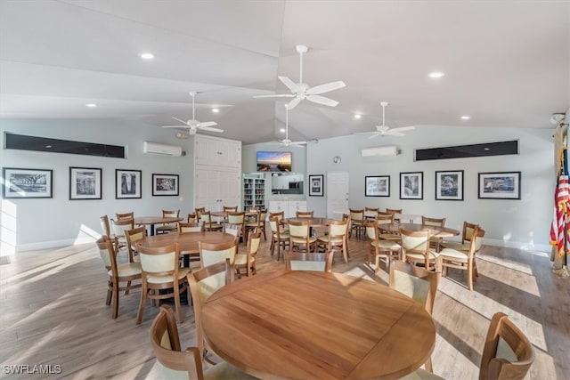 dining room with vaulted ceiling, ceiling fan, hardwood / wood-style floors, and a wall mounted air conditioner