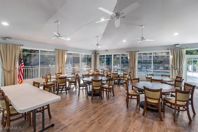 dining room featuring wood-type flooring, vaulted ceiling, ceiling fan, and plenty of natural light