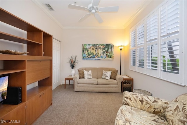 carpeted living room with ceiling fan and crown molding