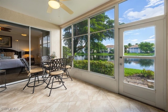 sunroom featuring a wealth of natural light, a water view, and ceiling fan