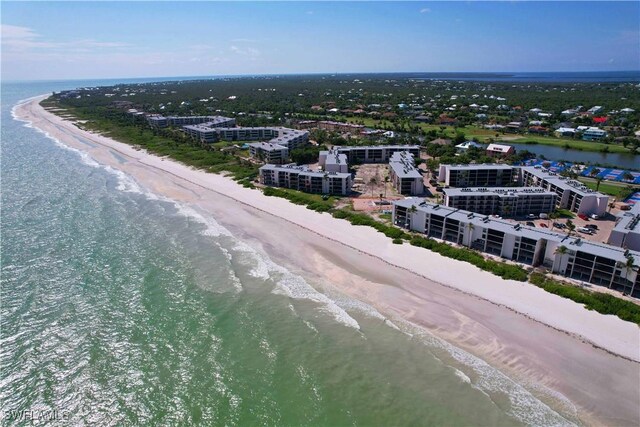 drone / aerial view featuring a water view and a beach view