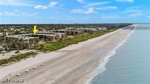 birds eye view of property with a water view and a beach view