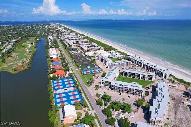 birds eye view of property featuring a water view and a beach view