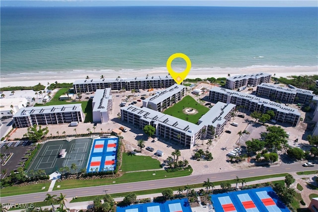 birds eye view of property featuring a water view and a beach view