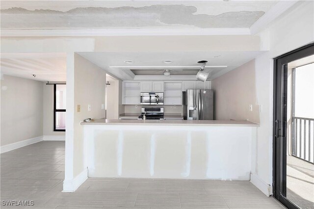 kitchen featuring stainless steel appliances, white cabinets, kitchen peninsula, and crown molding