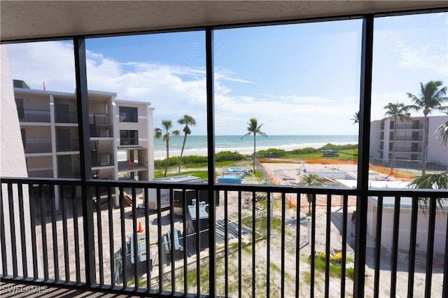 interior space with a water view and a beach view