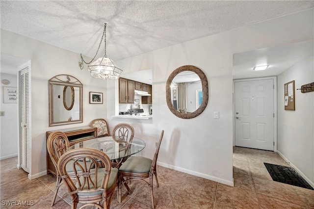 tiled dining room featuring a textured ceiling