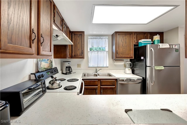 kitchen featuring a skylight, appliances with stainless steel finishes, and sink