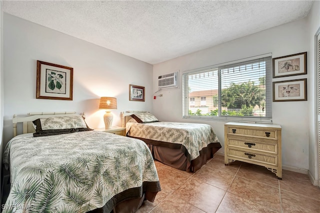 tiled bedroom featuring an AC wall unit and a textured ceiling