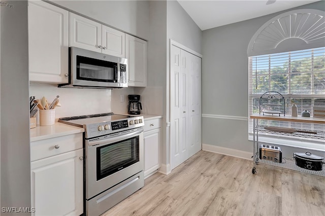 kitchen with white cabinetry, stainless steel appliances, and light wood-type flooring