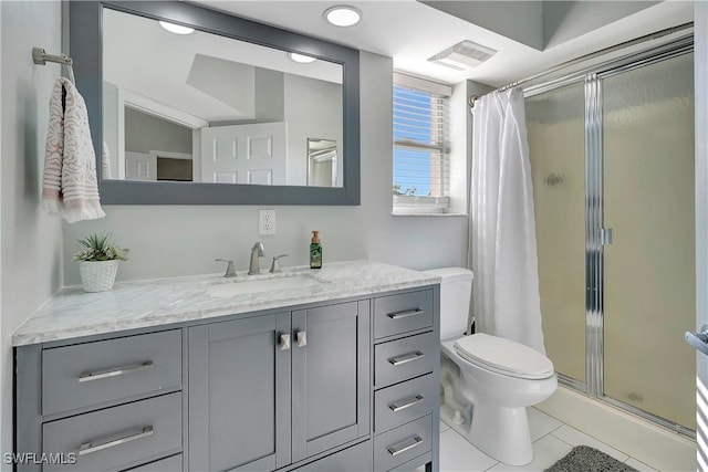 bathroom with vanity, toilet, tile patterned floors, and walk in shower