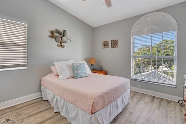 bedroom featuring lofted ceiling, light hardwood / wood-style flooring, and ceiling fan