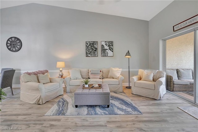 living room with vaulted ceiling and light hardwood / wood-style floors