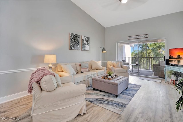 living room with light hardwood / wood-style flooring and high vaulted ceiling