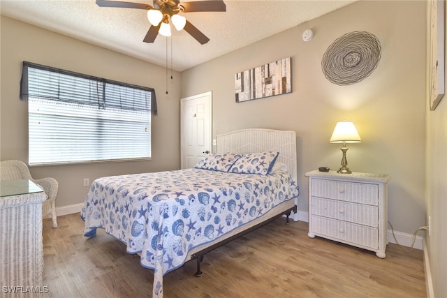 bedroom featuring a textured ceiling, hardwood / wood-style floors, and ceiling fan