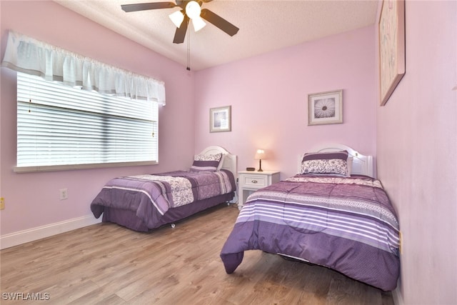 bedroom with ceiling fan, a textured ceiling, and light wood-type flooring