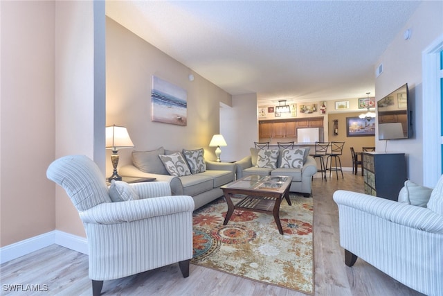 living room with light hardwood / wood-style floors and a textured ceiling