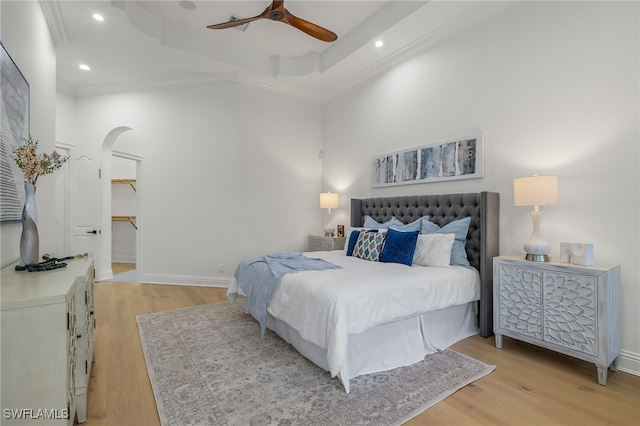 bedroom with light wood-type flooring, ceiling fan, and crown molding