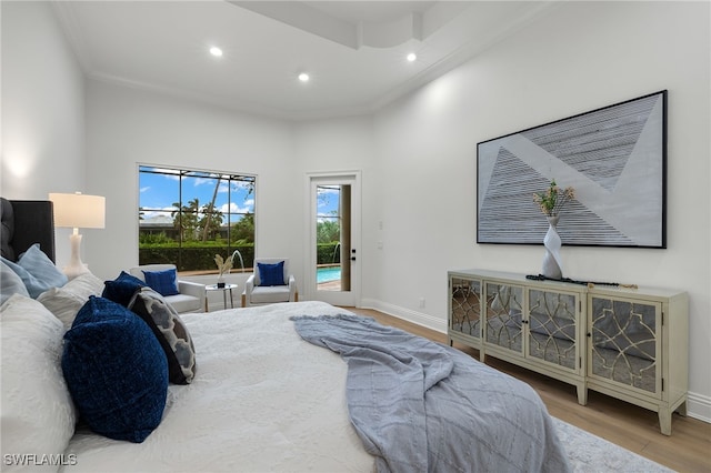 bedroom with access to exterior, wood-type flooring, and ornamental molding