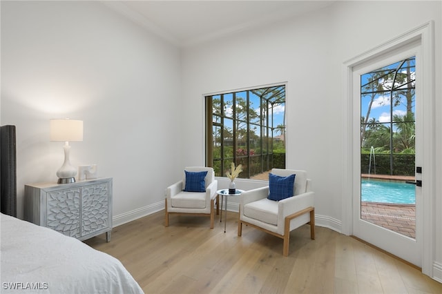 bedroom with access to outside, crown molding, and light hardwood / wood-style floors