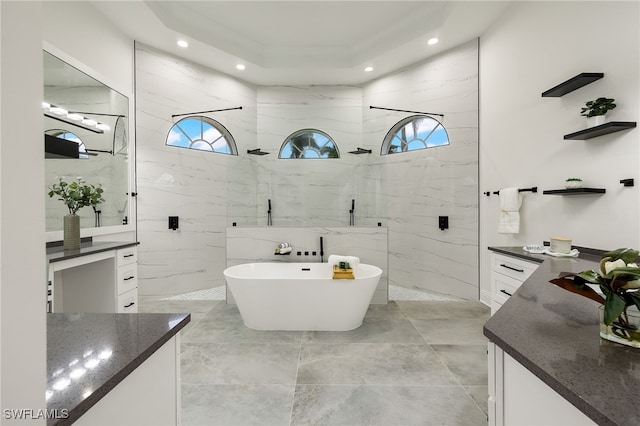 bathroom with a tray ceiling, plenty of natural light, vanity, and shower with separate bathtub