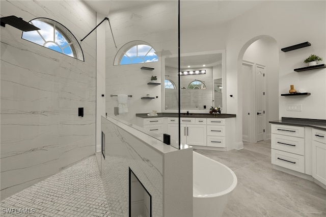 bathroom featuring shower with separate bathtub, vanity, and tile patterned floors