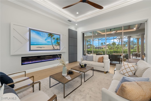 living room featuring light hardwood / wood-style floors, plenty of natural light, ornamental molding, and ceiling fan