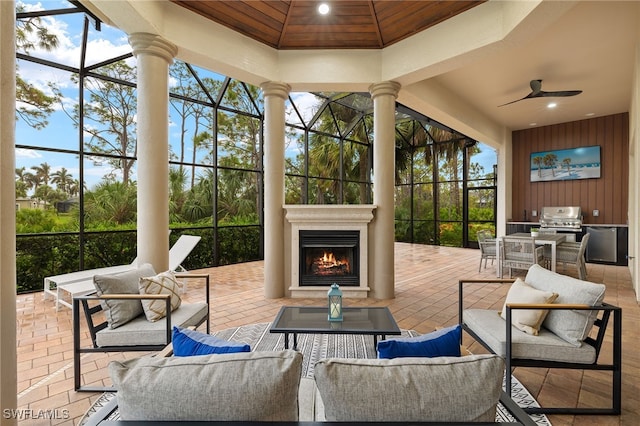 view of patio / terrace featuring an outdoor living space with a fireplace, ceiling fan, and area for grilling