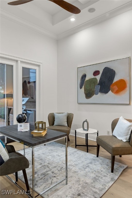 living area with hardwood / wood-style floors, ceiling fan, and ornamental molding