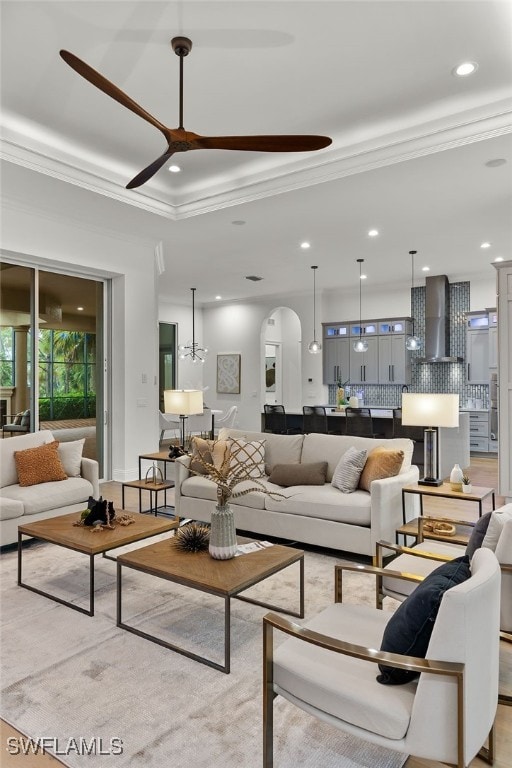 living room with ceiling fan and crown molding